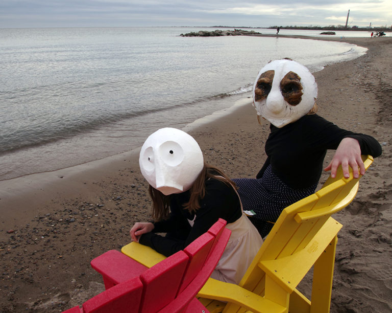 Animacy Theatre Collective's Morgan Johnson and Alexandra Siimpson in papier mache masks at Toronto Waterfront. Photography by Kathryn Hanson, ShutteredEye Photography.